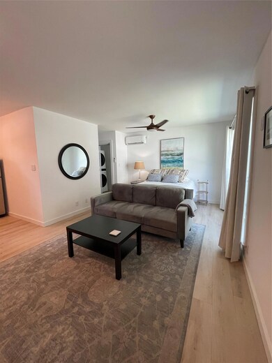 Living room featuring wood finished floors, a wal