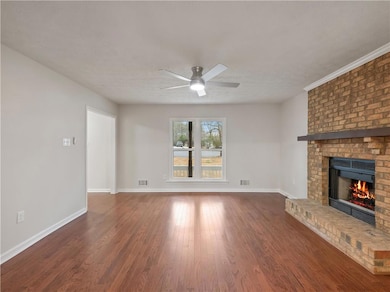 Unfurnished living room featuring a brick fireplac