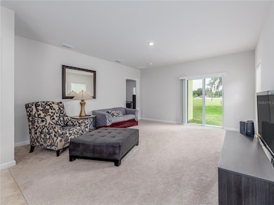 Wide open living room with patio and greenspace beyond.