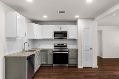 Kitchen featuring white cabinetry, sink, dark wood