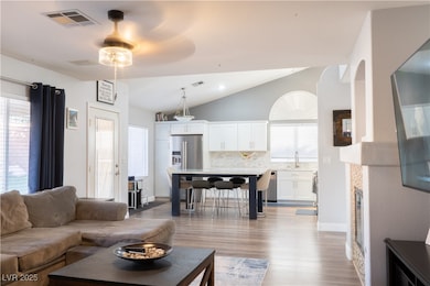 Living area with lofted ceiling, a ceiling fan, wo