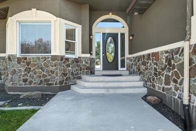 Doorway to property featuring stone siding and stucco siding