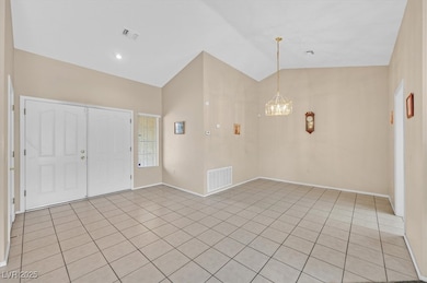 Foyer with light tile floors, and lofted ceiling