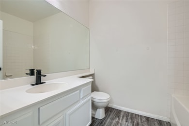 Bathroom with vanity, toilet, wood finished floors
