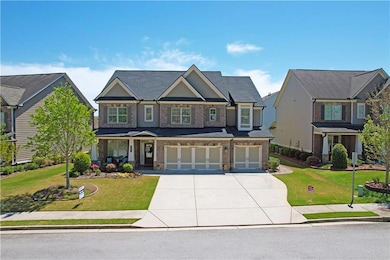 Craftsman-style home featuring a garage, concrete driveway, a front lawn, and brick siding