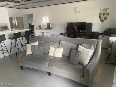 Living room with an office area and light tile pat