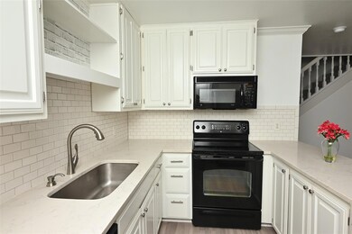 Kitchen featuring black appliances, a sink, white