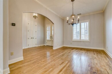 Arch opening to lovely Dining Room with hardwood f