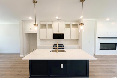 Kitchen featuring glass insert cabinets, dark cabinets, tasteful backsplash, light stone countertops, and recessed lighting