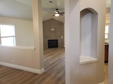 Hallway with wood finished floors, baseboards, an