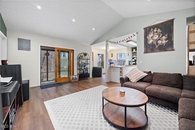 Living area featuring lofted ceiling, wood finished floors, and recessed lighting