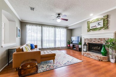 Living room featuring laminate-wood type flooriing, fireplace with mantel, gas logs and wall of windows for great lighting.