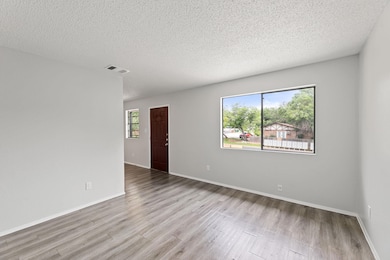 Unfurnished room with wood finished floors, a tex