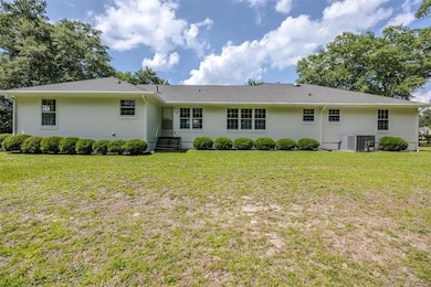 Back of property with a lawn