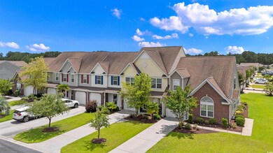 Multi unit property with a garage, driveway, a residential view, and a front lawn