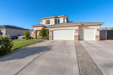 View of front facade featuring stone siding, stucco siding, a garage, driveway, and a tiled roof