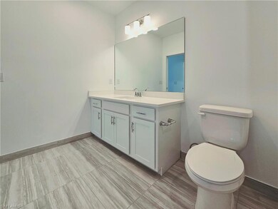 Bathroom with baseboards, toilet, and vanity