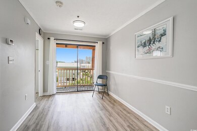 Living area featuring light wood-style flooring, ornamental molding, and a view of city