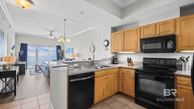 Kitchen with crown molding, black appliances, a peninsula, light tile patterned floors, and open floor plan