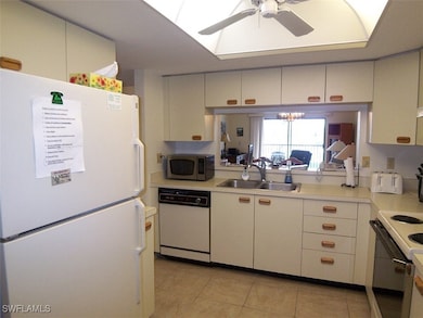 Kitchen featuring white appliances, light countert