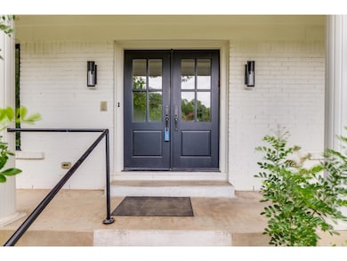 View of exterior entry with french doors and brick siding