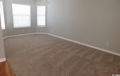 Spare room featuring wood finished floors, baseboa