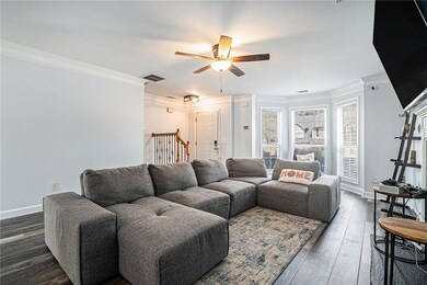Living area featuring crown molding, a ceiling fan, and dark wood finished floors