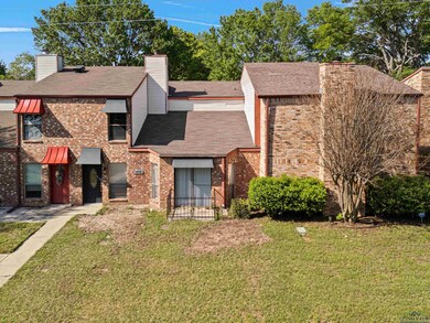 View of front of home featuring a front yard, brick siding, and a chimney