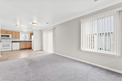 Unfurnished living room with light carpet and crown molding