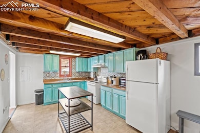 Kitchen featuring white appliances, blue cabinetry