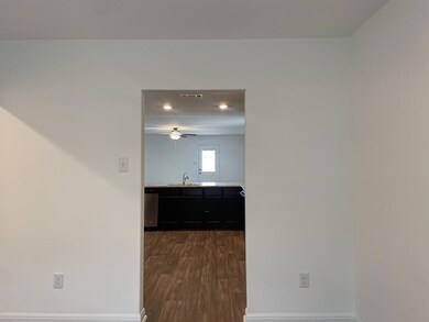 Hall with a sink, dark wood-style flooring, baseb