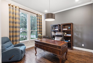 Office area with a healthy amount of sunlight, ornamental molding, and dark hardwood / wood-style flooring