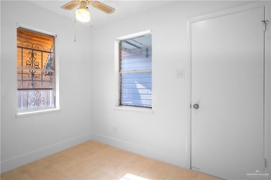 Spare room with a ceiling fan and tile patterned floors