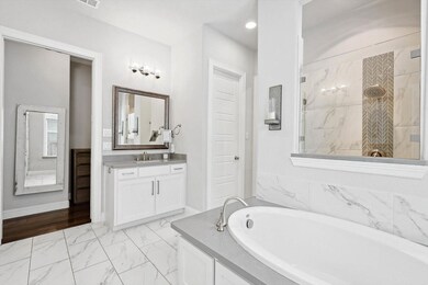 Bathroom featuring a bath, vanity, and tile floors