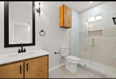Bathroom with vanity, toilet, tile patterned floors, and walk in shower