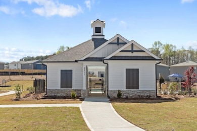 View of front of house featuring stone siding, a gate, and a shingled roof
