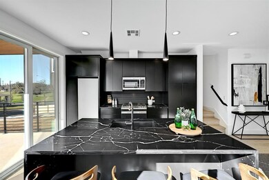 Kitchen with dark cabinetry, stainless steel micr