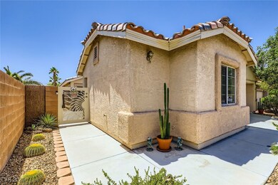 View of side of home featuring a gate, stucco sidi