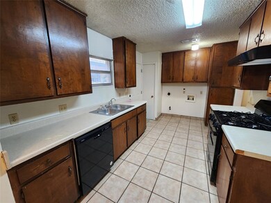 Kitchen featuring black appliances, exhaust hood,