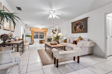 Living room with a textured ceiling, ceiling fan,