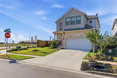 Traditional-style house featuring concrete driveway, a garage, stone siding, and a shingled roof