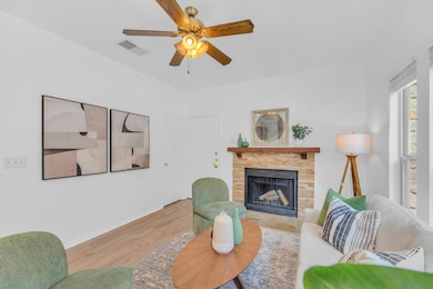 Living area with a ceiling fan, a fireplace, and 
