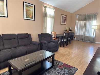 Living room with wood finished floors and lofted c