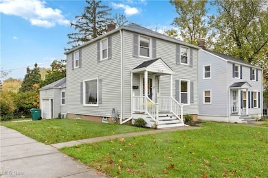 View of front of house with a chimney, a front lawn, and a garage
