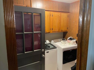 Clothes washing area with cabinets, wooden walls, 