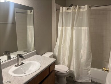 Bathroom with a textured wall, vanity, shower / tu