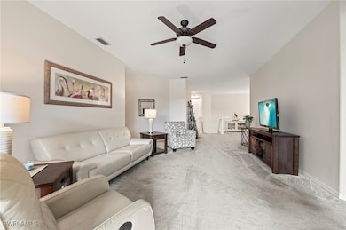 Carpeted living area with a ceiling fan and basebo