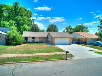 Single story home with a garage and a front yard