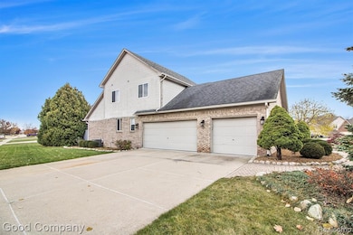 View of property exterior with roof with shingles, concrete driveway, a lawn, brick siding, and a garage