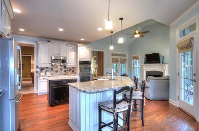 ANOTHER VIEW OF KITCHEN OPENING TO KEEPING AREA WITH FIREPLACE